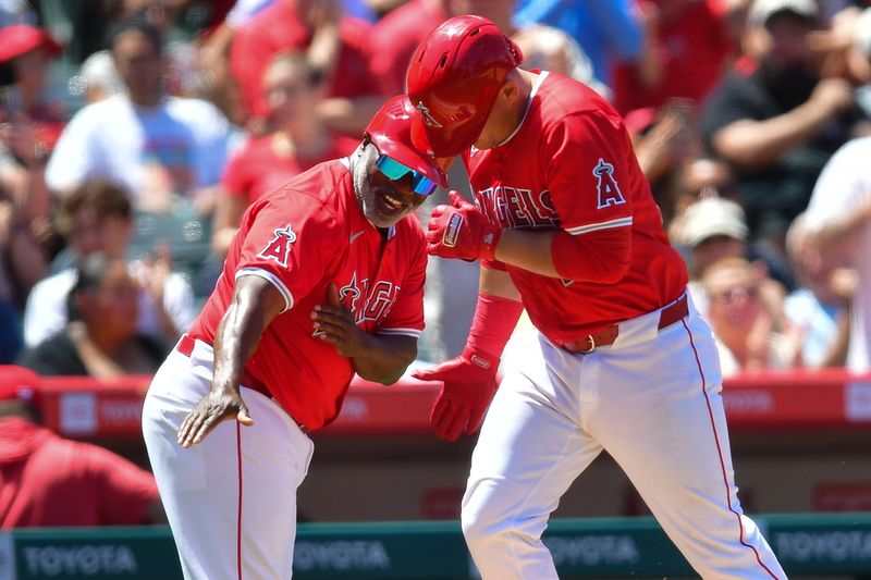 May 26, 2024; Anaheim, California, USA; Los Angeles Angels catcher Matt Thaiss (21) is greeted by third base coach Eric Young Sr. (85) after hitting a two run home run against the Cleveland Guardians during the fifth inning at Angel Stadium. Mandatory Credit: Gary A. Vasquez-USA TODAY Sports