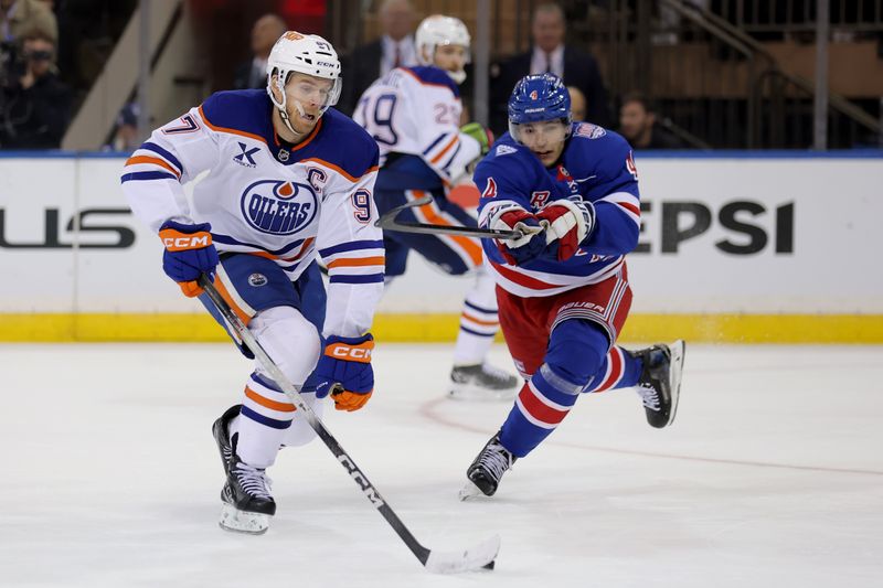 Oct 14, 2025; New York, New York, USA; Edmonton Oilers center Connor McDavid (97) skates with the puck against New York Rangers defenseman Braden Schneider (4) during the second period at Madison Square Garden. Mandatory Credit: Brad Penner-Imagn Images
