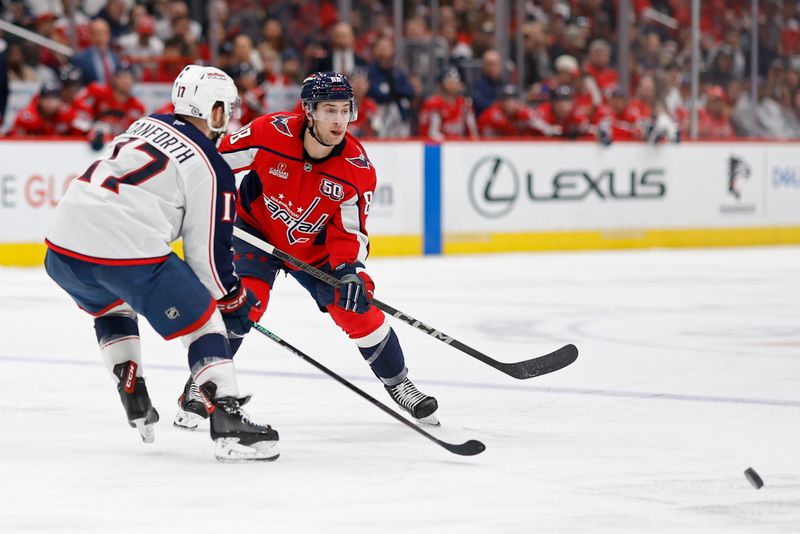 Nov 2, 2024; Washington, District of Columbia, USA; Washington Capitals left wing Andrew Mangiapane (88) passes the puck as Columbus Blue Jackets right wing Justin Danforth (17) defends in the third period at Capital One Arena. Mandatory Credit: Geoff Burke-Imagn Images