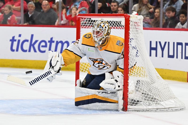 Apr 12, 2024; Chicago, Illinois, USA; Nashville Predators goaltender Kevin Lankinen (32) uses his stick to turn away a shot from the Chicago Blackhawks in the second period at United Center. Mandatory Credit: Jamie Sabau-USA TODAY Sports