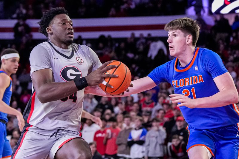 Feb 17, 2024; Athens, Georgia, USA; Georgia Bulldogs center Russel Tchewa (54) controls the ball against Florida Gators forward Alex Condon (21) during the first half at Stegeman Coliseum. Mandatory Credit: Dale Zanine-USA TODAY Sports