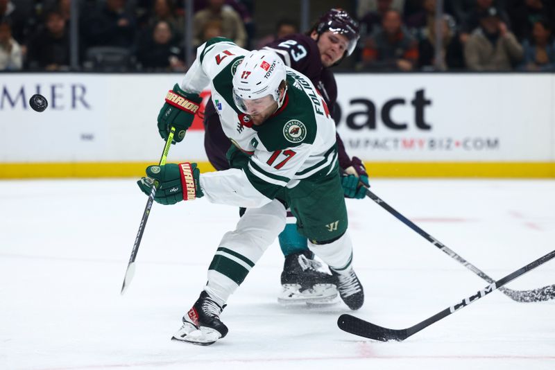 Mar 19, 2024; Anaheim, California, USA; Minnesota Wild left wing Marcus Foligno (17) fights for the puck against Anaheim Ducks center Mason McTavish (23) during the third period of a game at Honda Center. Mandatory Credit: Jessica Alcheh-USA TODAY Sports