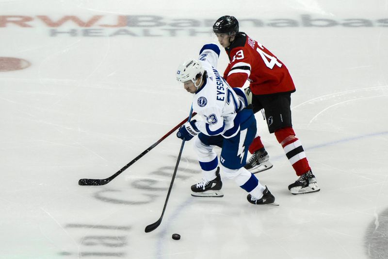 Feb 25, 2024; Newark, New Jersey, USA; Tampa Bay Lightning center Michael Eyssimont (23) skates with the puck while being defended by New Jersey Devils defenseman Luke Hughes (43) during the third period at Prudential Center. Mandatory Credit: John Jones-USA TODAY Sports