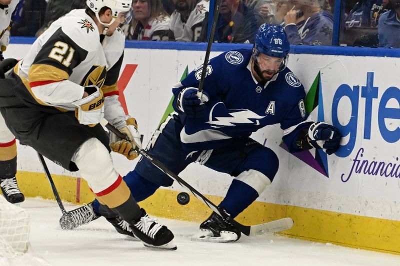  Dec 21, 2023; Tampa, Florida, USA; Tampa Bay Lightning right wing Nikita Kucherov (86) and Las Vegas Golden Knights center Brett Howden (21) look to control the puck in the first period at Amalie Arena. Mandatory Credit: Jonathan Dyer-USA TODAY Sports