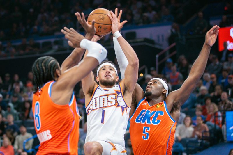 OKLAHOMA CITY, OKLAHOMA - NOVEMBER 15: Devin Booker #1 of the Phoenix Suns shoots the ball between Jalen Williams #8 and Luguentz Dort #5 of the Oklahoma City Thunder during the first quarter of the Emirates NBA Cup game at Paycom Center on November 15, 2024 in Oklahoma City, Oklahoma. NOTE TO USER: User expressly acknowledges and agrees that, by downloading and or using this photograph, User is consenting to the terms and conditions of the Getty Images License Agreement. (Photo by William Purnell/Getty Images)