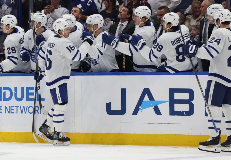 Apr 9, 2025; Tampa, Florida, USA; Toronto Maple Leafs right wing Mitch Marner (16) is congratulated by teammates after he scold a goal against the Tampa Bay Lightning during the first period at Amalie Arena. Mandatory Credit: Kim Klement Neitzel-Imagn Images
