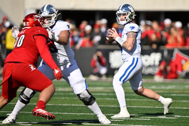 Nov 25, 2023; Louisville, Kentucky, USA;  Kentucky Wildcats quarterback Devin Leary (13) looks to pass against the Louisville Cardinals during the first quarter at L&N Federal Credit Union Stadium. Mandatory Credit: Jamie Rhodes-USA TODAY Sports