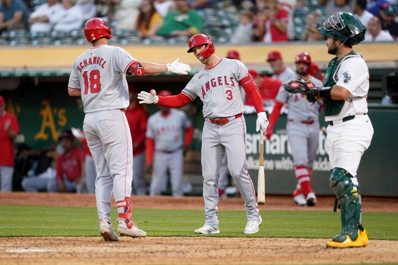 Jul 19, 2024; Oakland, California, USA; Los Angeles Angels first baseman Nolan Schanuel (18) is congratulated by left fielder Taylor Ward (3) after hitting a home run against the Oakland Athletics in the sixth inning at Oakland-Alameda County Coliseum. Mandatory Credit: Cary Edmondson-USA TODAY Sports