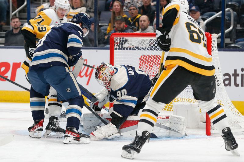 Nov 14, 2023; Columbus, Ohio, USA; Columbus Blue Jackets goalie Elvis Merzlikins (90) covers a loose puck in the crease against the Pittsburgh Penguins during the second period at Nationwide Arena. Mandatory Credit: Russell LaBounty-USA TODAY Sports