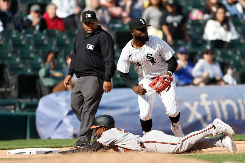 May 26, 2024; Chicago, Illinois, USA; Baltimore Orioles outfielder Cedric Mullins (31) advances to third base against Chicago White Sox third baseman Bryan Ramos (44) during the ninth inning at Guaranteed Rate Field. Mandatory Credit: Kamil Krzaczynski-USA TODAY Sports