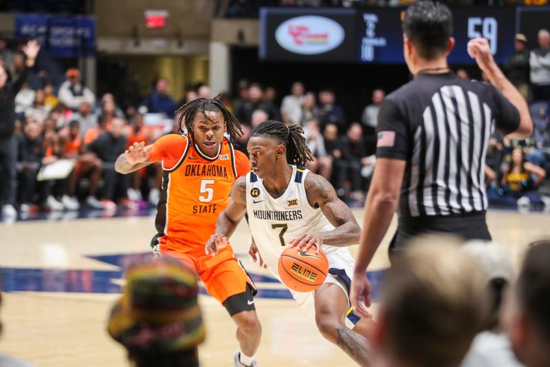 Jan 4, 2025; Morgantown, West Virginia, USA; West Virginia Mountaineers guard Javon Small (7) dribbles against Oklahoma State Cowboys guard Khalil Brantley (5) during the second half at WVU Coliseum. Mandatory Credit: Ben Queen-Imagn Images