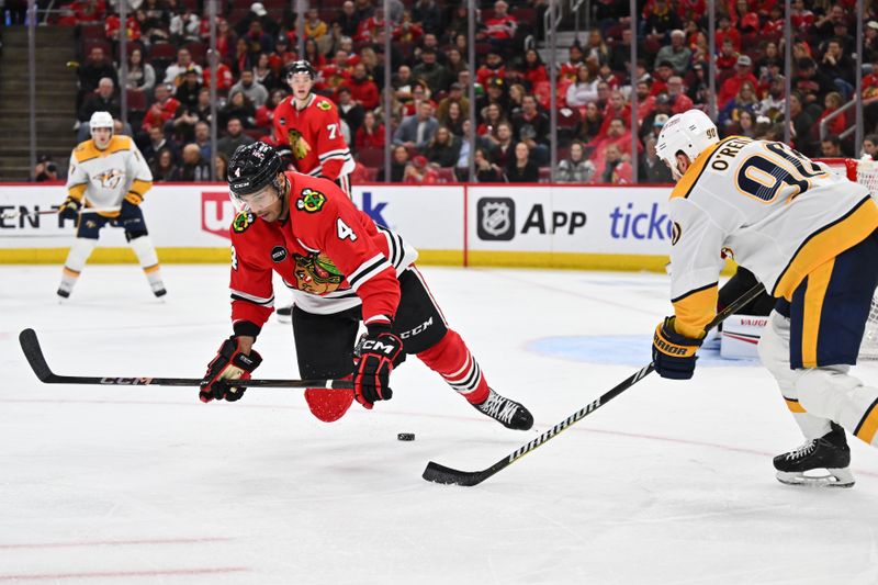 Apr 12, 2024; Chicago, Illinois, USA; Chicago Blackhawks defenseman Seth Jones (4) loses the puck as he falls to the ice in the third period against the Nashville Predators at United Center. Mandatory Credit: Jamie Sabau-USA TODAY Sports