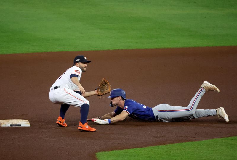 Oct 23, 2023; Houston, Texas, USA; Texas Rangers center fielder Evan Carter (32) steals second in front of Houston Astros second baseman Jose Altuve (27) during the first inning of game seven in the ALCS for the 2023 MLB playoffs at Minute Maid Park.  Mandatory Credit: Troy Taormina-USA TODAY Sports