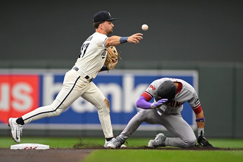 Aug 6, 2023; Minneapolis, Minnesota, USA; Minnesota Twins infielder Edouard Julien (47) throws to first over a sliding Arizona Diamondbacks outfielder Lourdes Gurriel (12) on an unsuccessful double play attempt during the second inning at Target Field. Mandatory Credit: Nick Wosika-USA TODAY Sports