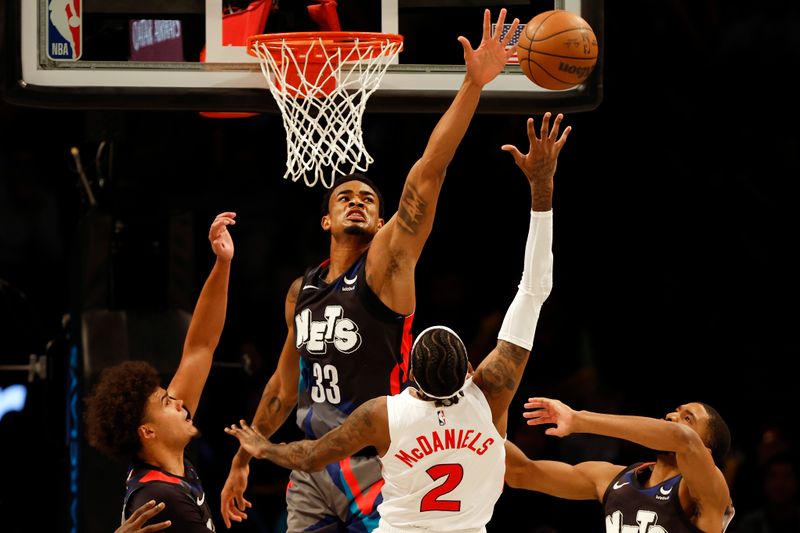 NEW YORK, NEW YORK - NOVEMBER 28: Nic Claxton #33 of the Brooklyn Nets blocks a shot by Jalen McDaniels #2 of the Toronto Raptors during the second half of an NBA In-Season Tournament game at Barclays Center on November 28, 2023 in the Brooklyn borough of New York City. The Nets won 115-103. NOTE TO USER: User expressly acknowledges and agrees that, by downloading and/or using this photograph, User is consenting to the terms and conditions of the Getty Images License Agreement. (Photo by Sarah Stier/Getty Images)