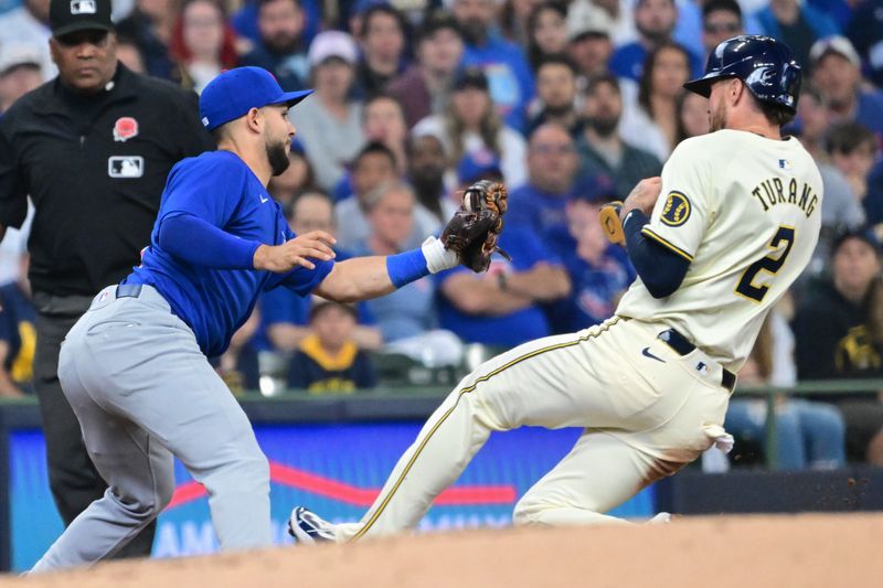 May 27, 2024; Milwaukee, Wisconsin, USA; Chicago Cubs third baseman Nick Madrigal (1) tags Milwaukee Brewers second baseman Brice Turang (2) out trying to steal third base in the third inning at American Family Field. Mandatory Credit: Benny Sieu-USA TODAY Sports