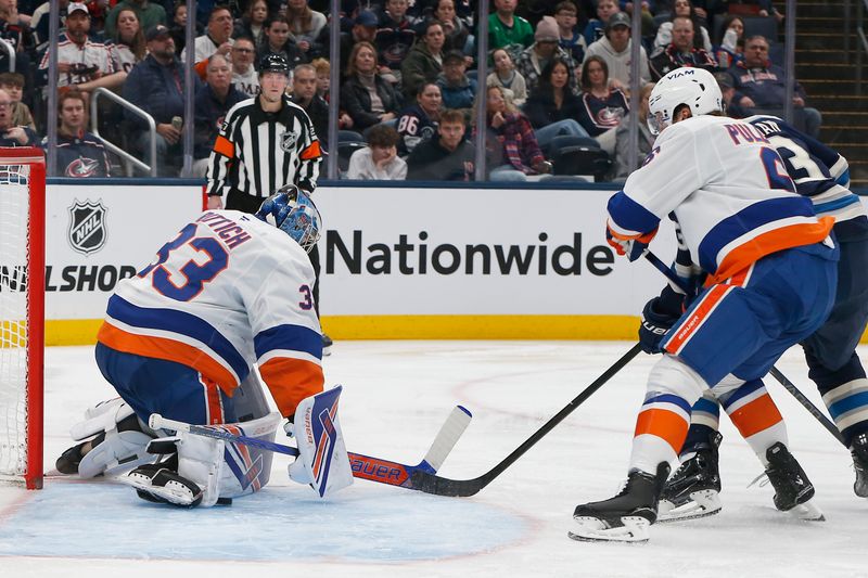 Dec 28, 2025; Columbus, Ohio, USA; New York Islanders goalie David Rittich (33) makes a pad save from the shot of  Columbus Blue Jackets center Sean Monahan (23) during the second period at Nationwide Arena. Mandatory Credit: Russell LaBounty-Imagn Images