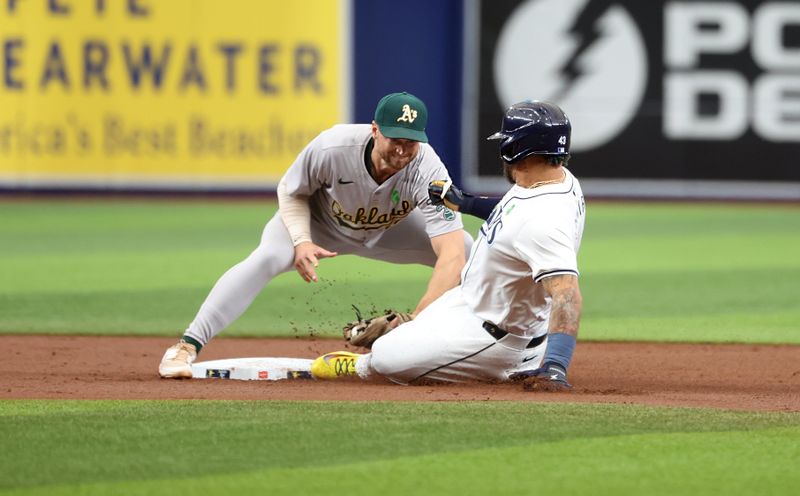 May 30, 2024; St. Petersburg, Florida, USA; Oakland Athletics shortstop Max Schuemann (12) tags out Tampa Bay Rays outfielder Harold Ramírez (43) during the first inning at Tropicana Field. Mandatory Credit: Kim Klement Neitzel-USA TODAY Sports