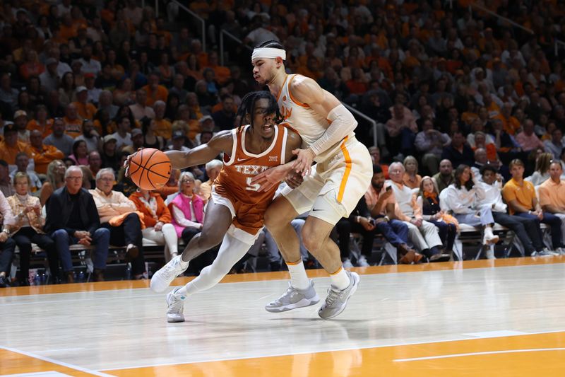 Jan 28, 2023; Knoxville, Tennessee, USA; Texas Longhorns guard Marcus Carr (5) moves the ball against Tennessee Volunteers forward Olivier Nkamhoua (13) during the second half at Thompson-Boling Arena. Mandatory Credit: Randy Sartin-USA TODAY Sports