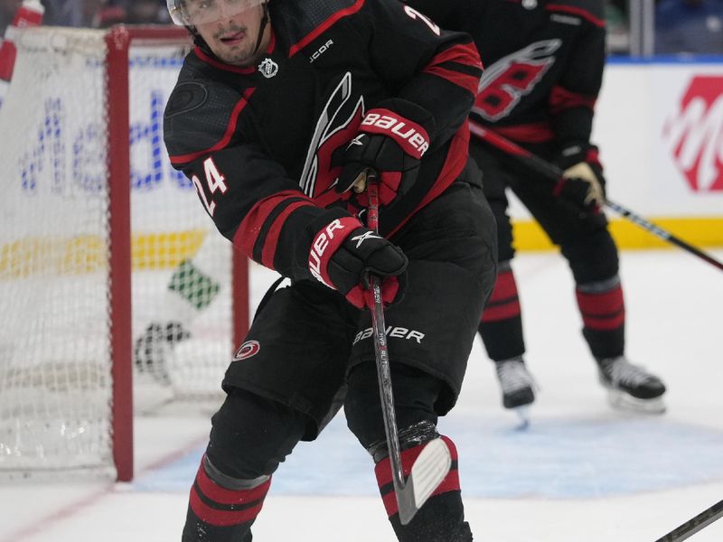 Mar 16, 2024; Toronto, Ontario, CAN; Carolina Hurricanes forward Seth Jarvis (24) clears the puck against the Toronto Maple Leafs during the third period at Scotiabank Arena. Mandatory Credit: John E. Sokolowski-USA TODAY Sports