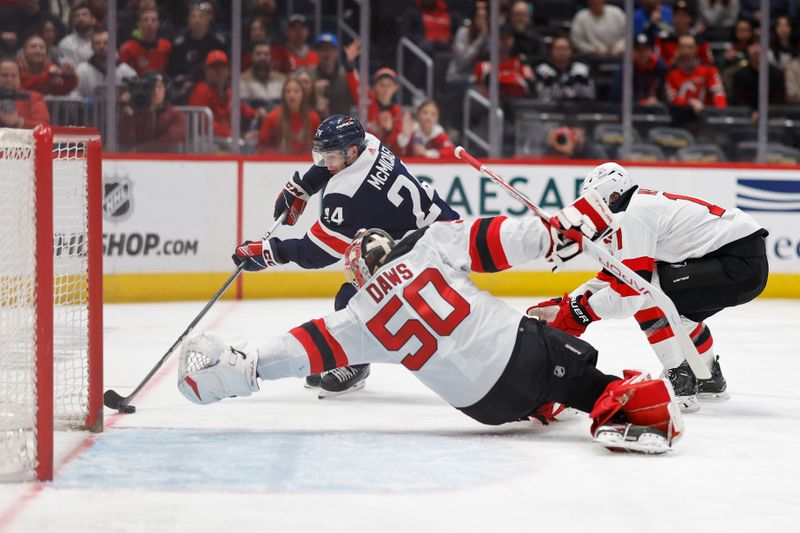 Feb 20, 2024; Washington, District of Columbia, USA; Washington Capitals center Connor McMichael (24) scores a goal on New Jersey Devils goaltender Nico Daws (50) as Devils center Chris Tierney (11) defends in the second period at Capital One Arena. Mandatory Credit: Geoff Burke-USA TODAY Sports