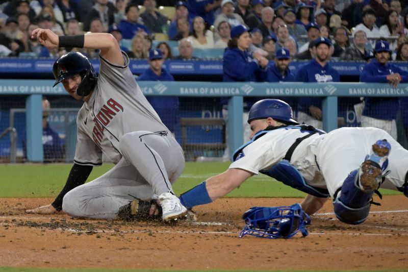 May 20, 2024; Los Angeles, California, USA;  Arizona Diamondbacks shortstop Kevin Newman (18) beats the tag by Los Angeles Dodgers catcher Will Smith (16) as he scores on a single by designated hitter Joc Pederson (3) in the third inning at Dodger Stadium. Mandatory Credit: Jayne Kamin-Oncea-USA TODAY Sports