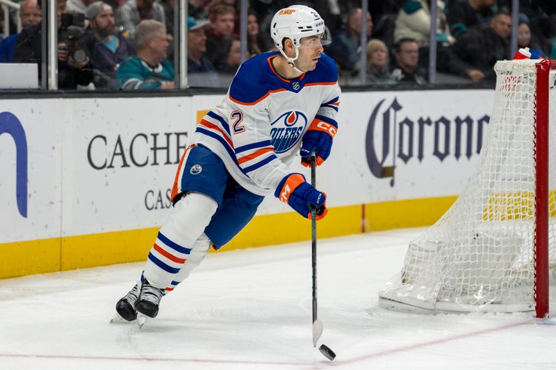 Dec 28, 2023; San Jose, California, USA; Edmonton Oilers defenseman Evan Bouchard (2) skates with the puck behind the net during the second period against the San Jose Sharks at SAP Center at San Jose. Mandatory Credit: Neville E. Guard-USA TODAY Sports