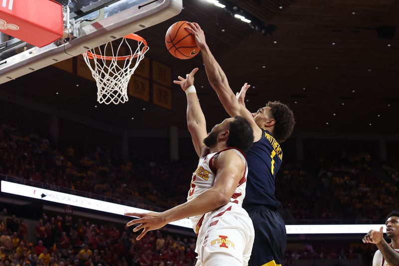 Feb 27, 2023; Ames, Iowa, USA; West Virginia Mountaineers forward Emmitt Matthews Jr. (1) blocks the shot of Iowa State Cyclones guard Jaren Holmes (13) during the second half at James H. Hilton Coliseum. Mandatory Credit: Reese Strickland-USA TODAY Sports