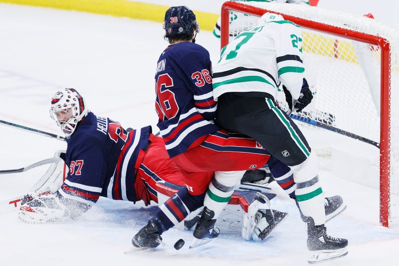 Nov 9, 2024; Winnipeg, Manitoba, CAN; Winnipeg Jets center Morgan Barron (36) and Dallas Stars left wing Mason Marchment (27) scramble for the puck over a fallen Winnipeg Jets goaltender Connor Hellebuyck (37) in the third period at Canada Life Centre. Mandatory Credit: James Carey Lauder-Imagn Images