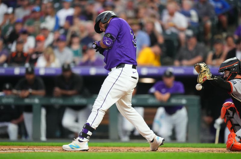 Jul 19, 2024; Denver, Colorado, USA; Colorado Rockies catcher Elias Díaz (35) is hit by a pitch in the sixth inning against the San Francisco Giants at Coors Field. Mandatory Credit: Ron Chenoy-USA TODAY Sports