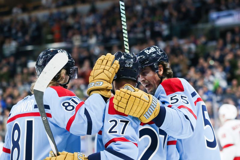 Dec 4, 2023; Winnipeg, Manitoba, CAN; Winnipeg Jets forward Nikolaj Ehlers (27) is congratulated by his teammates on his goal against Carolina Hurricanes goalie Antti Raanta (32) during the second period at Canada Life Centre. Mandatory Credit: Terrence Lee-USA TODAY Sports