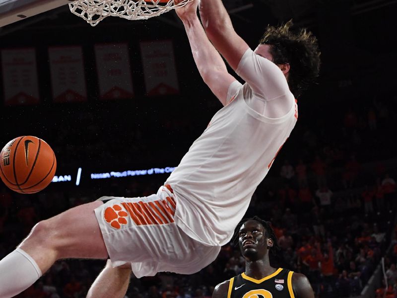 Feb 27, 2024; Clemson, South Carolina, USA; Clemson junior forward Ian Schieffelin (4) dunks near Pitt center Federiko Federiko (33) during the second half at Littlejohn Coliseum. Mandatory Credit: Ken Ruinard-USA TODAY Sports