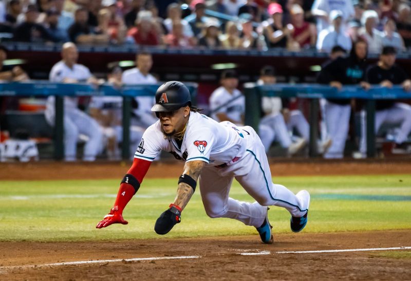 Aug 27, 2023; Phoenix, Arizona, USA; Arizona Diamondbacks base runner Ketel Marte dives into home to score in the eighth inning against the Cincinnati Reds at Chase Field. Mandatory Credit: Mark J. Rebilas-USA TODAY Sports