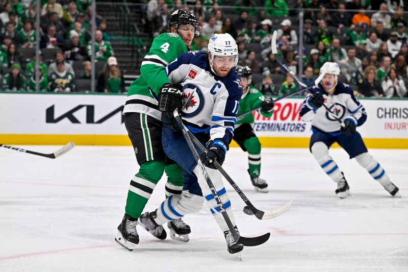 Dec 1, 2024; Dallas, Texas, USA; Winnipeg Jets center Adam Lowry (17) redirects the puck past Dallas Stars defenseman Miro Heiskanen (4) to score a goal against goaltender Jake Oettinger (not pictured) during the first period at the American Airlines Center. Mandatory Credit: Jerome Miron-Imagn Images