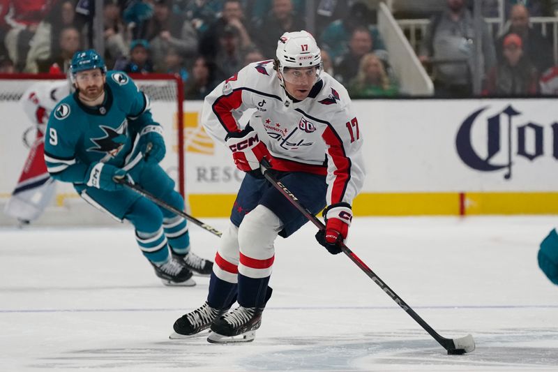 Mar 15, 2025; San Jose, California, USA;  Washington Capitals center Dylan Strome (17) advances the puck past San Jose Sharks center Noah Gregor (9) in the first period at SAP Center at San Jose. Mandatory Credit: David Gonzales-Imagn Images
