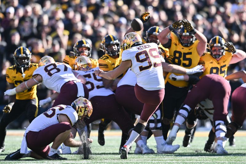 Oct 21, 2023; Iowa City, Iowa, USA; Minnesota Golden Gophers place kicker Dragan Kesich (99) kicks a 43 yard field goal as holder Mark Crawford (96) holds during the second quarter against the Iowa Hawkeyes at Kinnick Stadium. Mandatory Credit: Jeffrey Becker-USA TODAY Sports