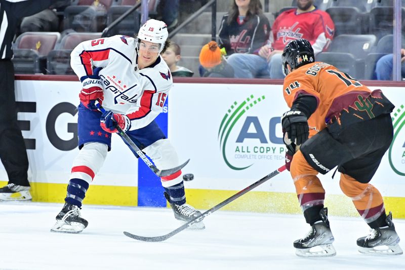 Jan 19, 2023; Tempe, Arizona, USA; Washington Capitals left wing Sonny Milano (15) passes the puck over the stick of Arizona Coyotes defenseman Shayne Gostisbehere (14) in the first period at Mullett Arena. Mandatory Credit: Matt Kartozian-USA TODAY Sports