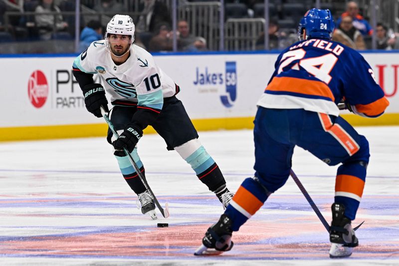 Feb 13, 2024; Elmont, New York, USA; Seattle Kraken center Matty Beniers (10) skates across center ice defended by New York Islanders defenseman Scott Mayfield (24) during the third period at UBS Arena. Mandatory Credit: Dennis Schneidler-USA TODAY Sports