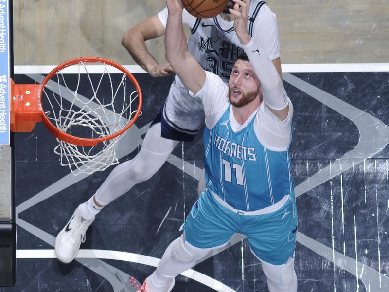 ORLANDO, FL - FEBRUARY 12: Jusuf Nurkic #11 of the Charlotte Hornets goes up for the rebound during the game against the Orlando Magic on February 12, 2025 at Kia Center in Orlando, Florida. NOTE TO USER: User expressly acknowledges and agrees that, by downloading and or using this photograph, User is consenting to the terms and conditions of the Getty Images License Agreement. Mandatory Copyright Notice: Copyright 2025 NBAE (Photo by Fernando Medina/NBAE via Getty Images)