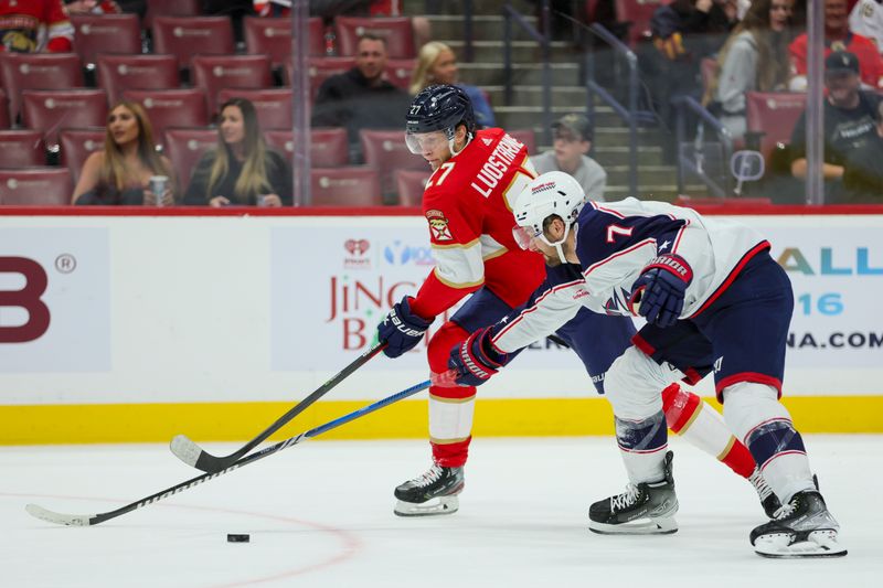 Nov 6, 2023; Sunrise, Florida, USA; Florida Panthers center Eetu Luostarinen (27) and Columbus Blue Jackets center Sean Kuraly (7) battle for the puck during the first period at Amerant Bank Arena. Mandatory Credit: Sam Navarro-USA TODAY Sports