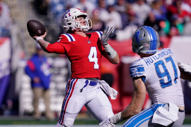 New England Patriots quarterback Bailey Zappe (4) passes while pressured by Detroit Lions defensive end Aidan Hutchinson (97) during an NFL football game, Sunday, Oct. 9, 2022, in Foxborough, Mass. (AP Photo/Charles Krupa)