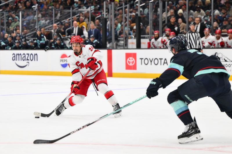 Oct 26, 2024; Seattle, Washington, USA; Carolina Hurricanes center Seth Jarvis (24) passes the puck against the Seattle Kraken during the second period at Climate Pledge Arena. Mandatory Credit: Steven Bisig-Imagn Images