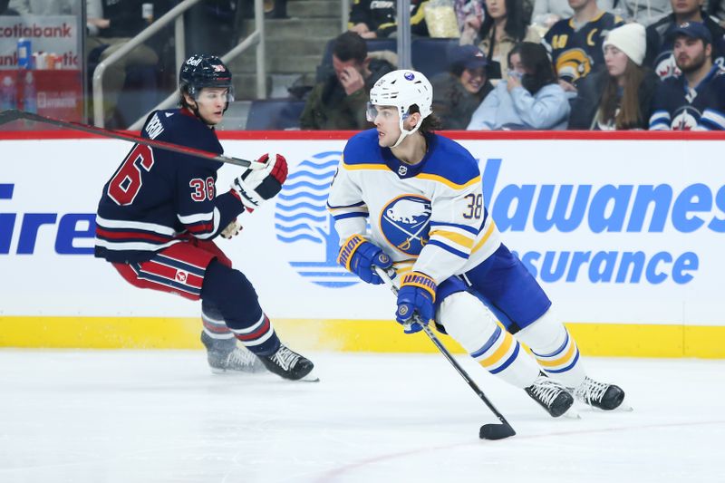 Jan 26, 2023; Winnipeg, Manitoba, CAN;  Buffalo Sabres defenseman Kale Clague (38) skates away from Winnipeg Jets forward Morgan Barron (36) during the second period at Canada Life Centre. Mandatory Credit: Terrence Lee-USA TODAY Sports