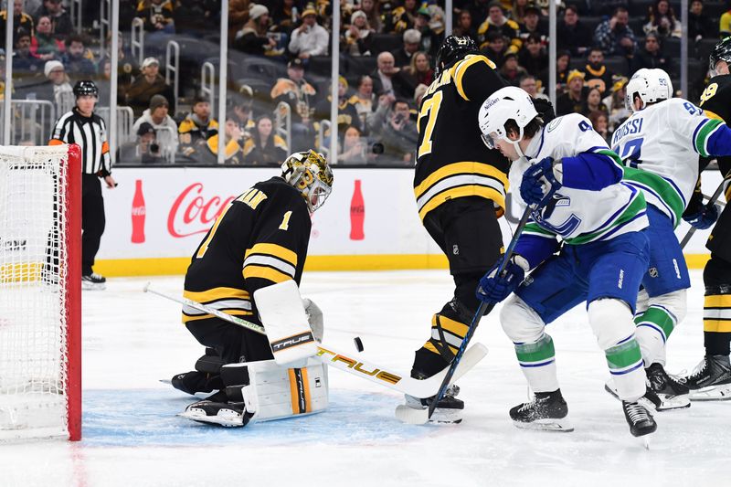 Dec 20, 2025; Boston, Massachusetts, USA; Boston Bruins goaltender Jeremy Swayman (1) makes a save in front of Vancouver Canucks right wing Conor Garland (8) and defenseman Hampus Lindholm (27) during the second period at TD Garden. Mandatory Credit: Bob DeChiara-Imagn Images