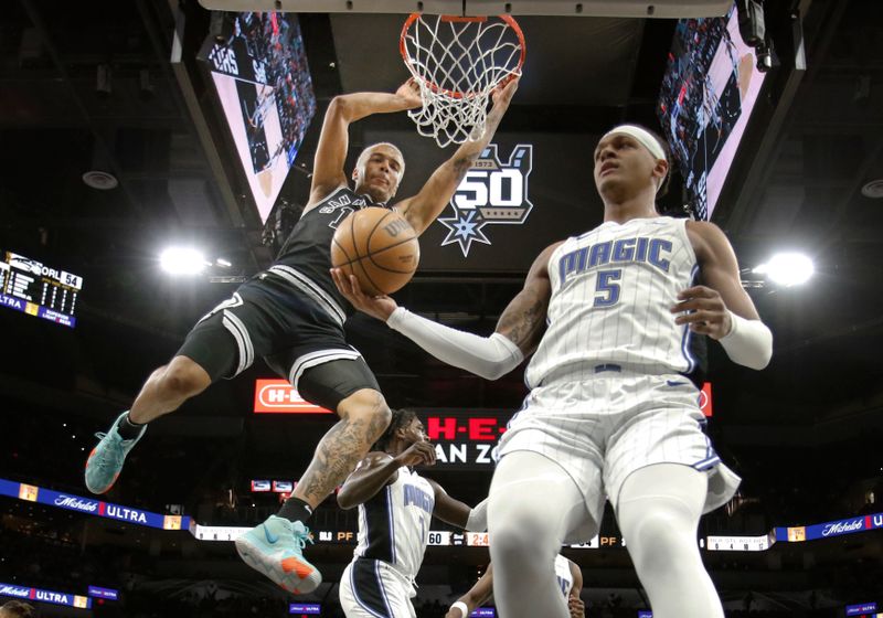 SAN ANTONIO, TX - MARCH 14: Jeremy Sochan #10 of the San Antonio Spurs dunks past Paolo Banchero #5 of the Orlando Magic in the first half at AT&T Center on March 14, 2023 in San Antonio, Texas. NOTE TO USER: User expressly acknowledges and agrees that, by downloading and or using this photograph, User is consenting to terms and conditions of the Getty Images License Agreement. (Photo by Ronald Cortes/Getty Images)