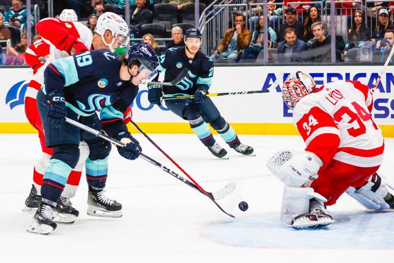 Feb 19, 2024; Seattle, Washington, USA; Seattle Kraken left wing Jared McCann (19) scores a goal against Detroit Red Wings goaltender Alex Lyon (34) during the second period at Climate Pledge Arena. Mandatory Credit: Joe Nicholson-USA TODAY Sports