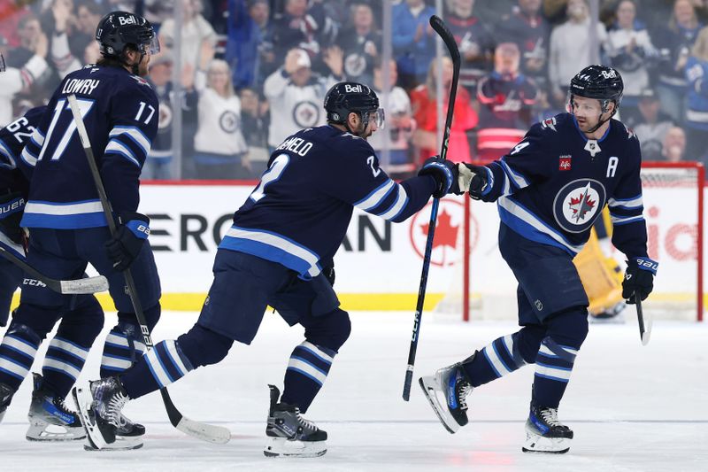 Jan 7, 2025; Winnipeg, Manitoba, CAN; Winnipeg Jets defenseman Josh Morrissey (44) celebrates his first period goal with Winnipeg Jets defenseman Dylan DeMelo (2) against the Nashville Predators at Canada Life Centre. Mandatory Credit: James Carey Lauder-Imagn Images