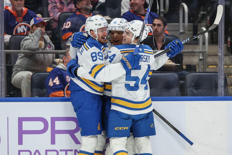 Nov 22, 2025; Elmont, New York, USA;  St. Louis Blues center Brayden Schenn (10) celebrates with left wing Pavel Buchnevich (89) and right wing Dalibor Dvorsky (54) after scoring a goal in the first period against the New York Islanders at UBS Arena. Mandatory Credit: Wendell Cruz-Imagn Images