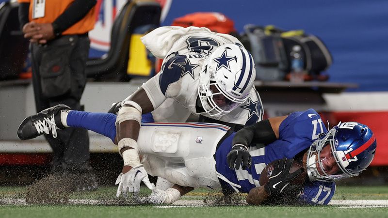 Dallas Cowboys linebacker DeMarvion Overshown (13) tackles New York Giants wide receiver Wan'Dale Robinson (17) during the third quarter of an NFL football game, Thursday, Sept. 26, 2024, in East Rutherford, N.J. (AP Photo/Adam Hunger)