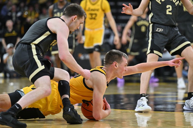 Jan 20, 2024; Iowa City, Iowa, USA; Iowa Hawkeyes forward Payton Sandfort (20) and Purdue Boilermakers guard Braden Smith (3) scramble for a loose ball during the second half at Carver-Hawkeye Arena. Sandfort called a time out on the play. Mandatory Credit: Jeffrey Becker-USA TODAY Sports